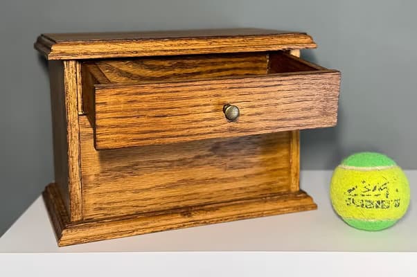 Oak pet ashes casket with an open keepsake drawer